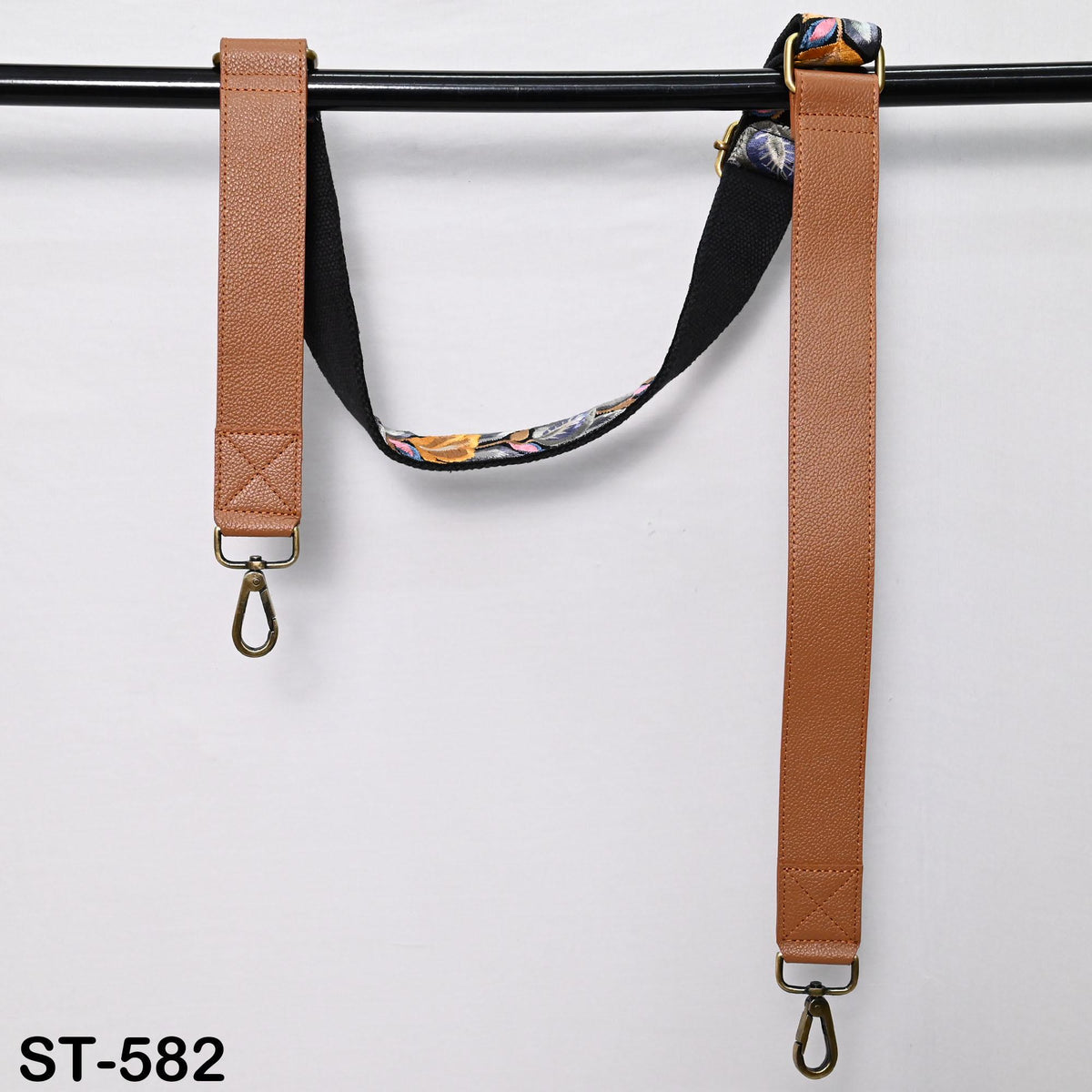 two leather straps hanging on a black bar.