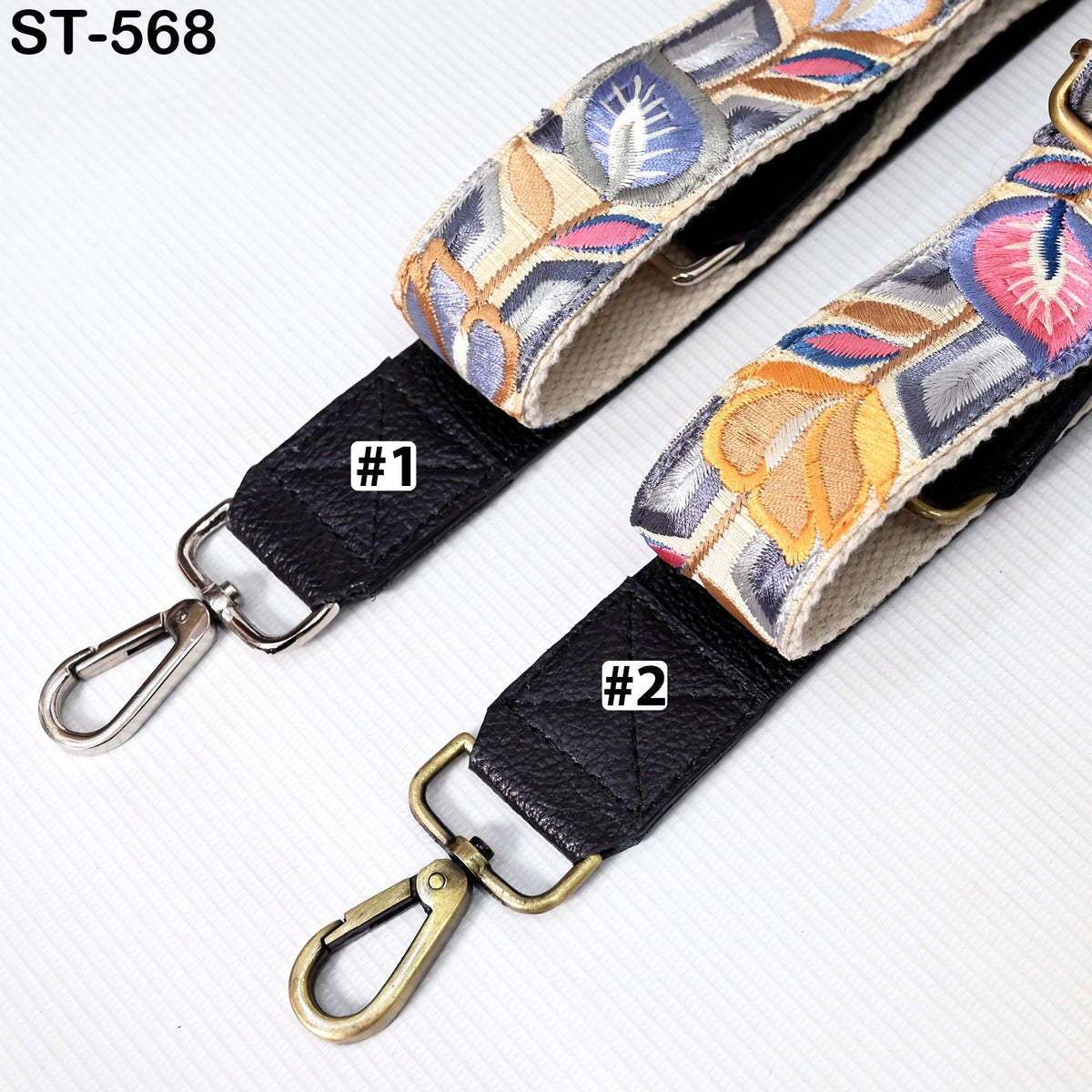 two colorful straps with floral patterns, one with a black strap and the other with a gold strap, both featuring metal hooks and buckles.