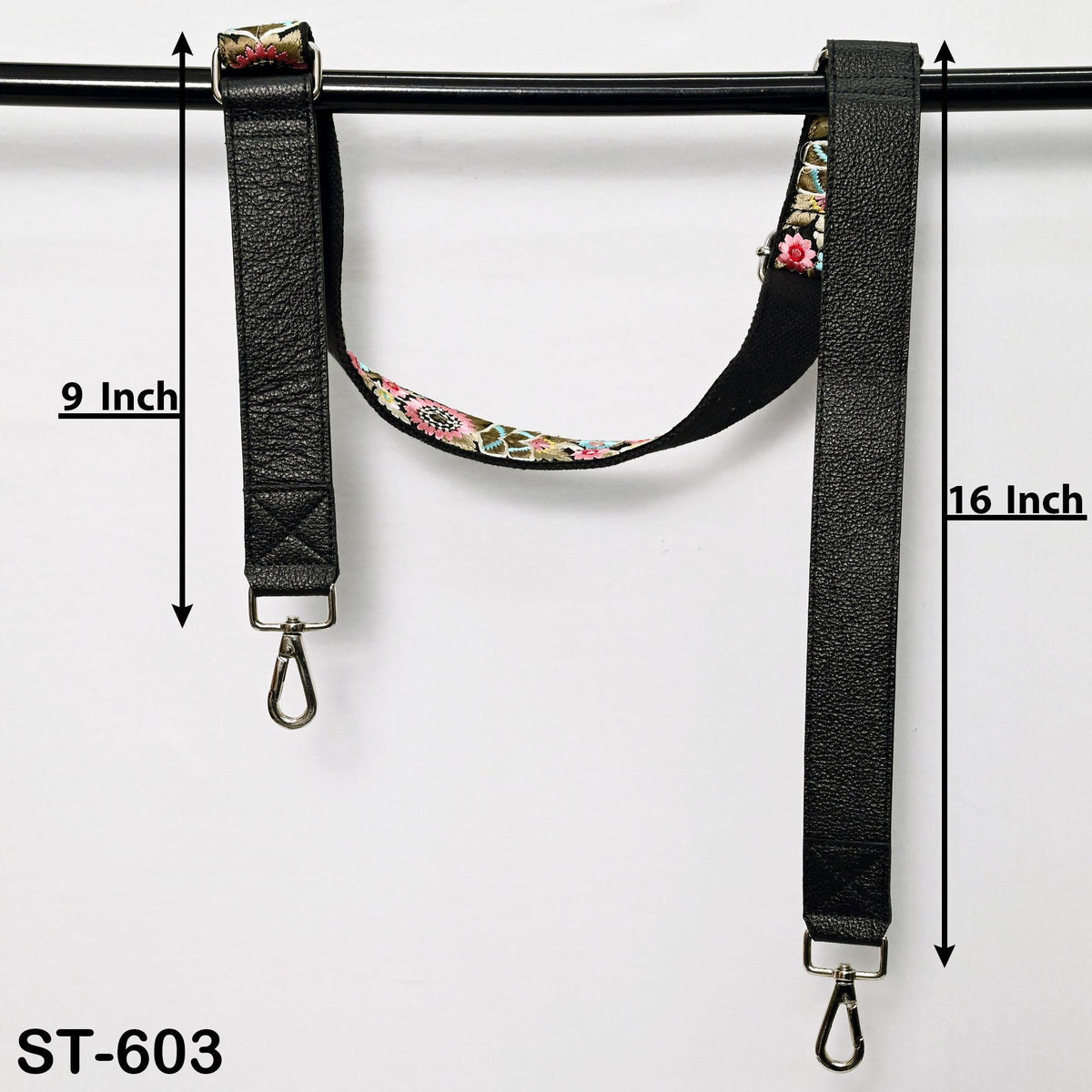 two black leather straps with floral patterns, hanging from a black metal bar. The straps are 9 inches and 16 inches long, respectively.