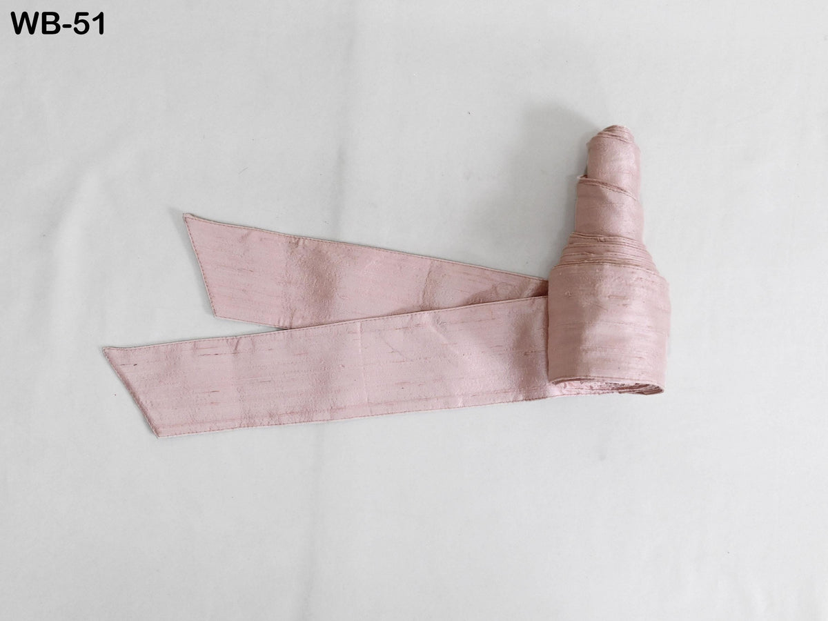 A pink fabric item, possibly a ribbon or scarf, is shown on a white background.