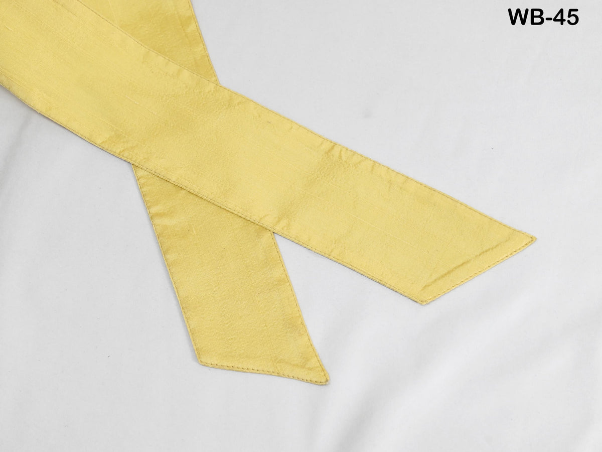 a yellow fabric, possibly a ribbon or tie, with a white background.