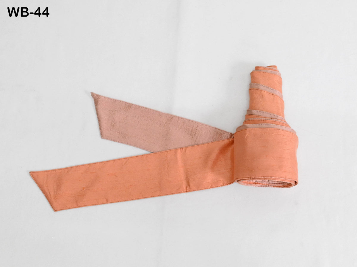 a rolled-up orange fabric or ribbon against a white background.