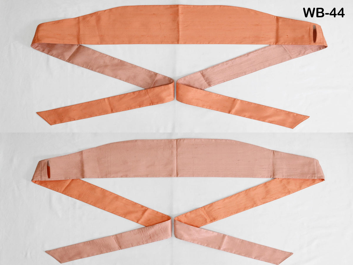 two different colored ribbons, one orange and one pink, arranged in a cross pattern on a white background.