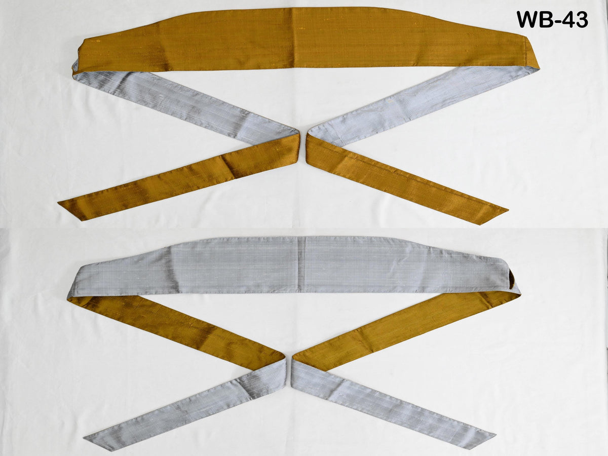 two fabric items, one with a gold-colored fabric and the other with a gray-colored fabric, both tied in a cross-like pattern.
