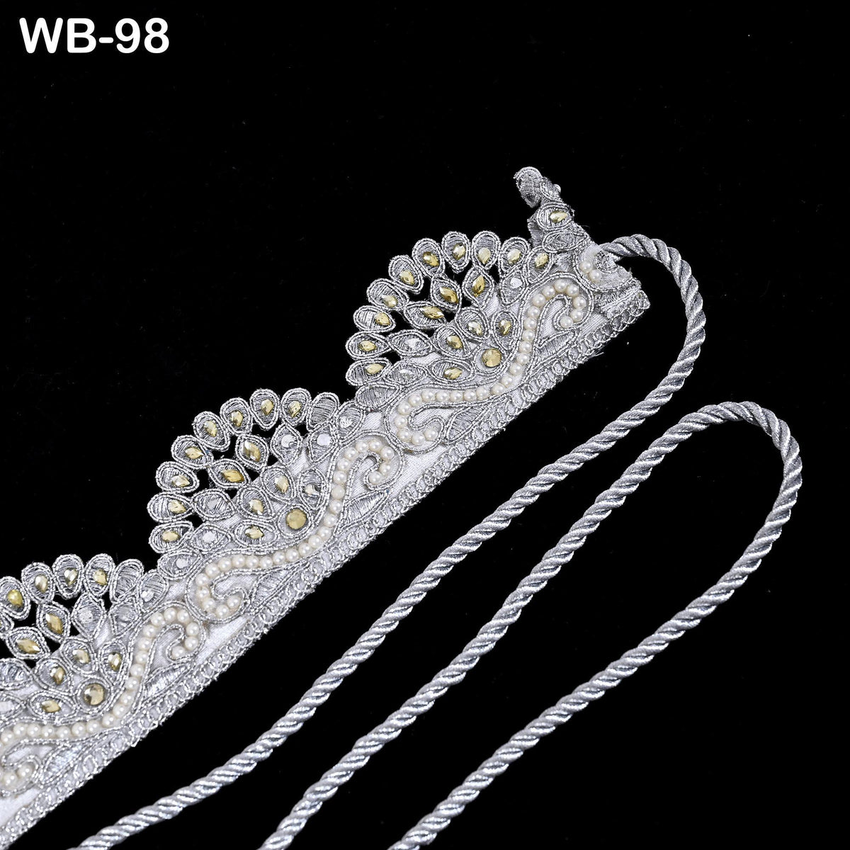 A decorative silver and white piece of fabric or material with intricate floral and leaf designs, possibly a headband or accessory.
