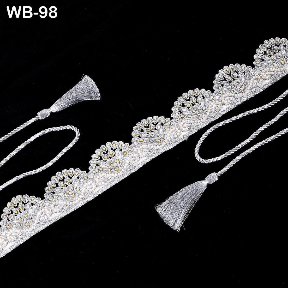 a decorative silver-colored fabric with a floral pattern and tassels attached to it, set against a black background.