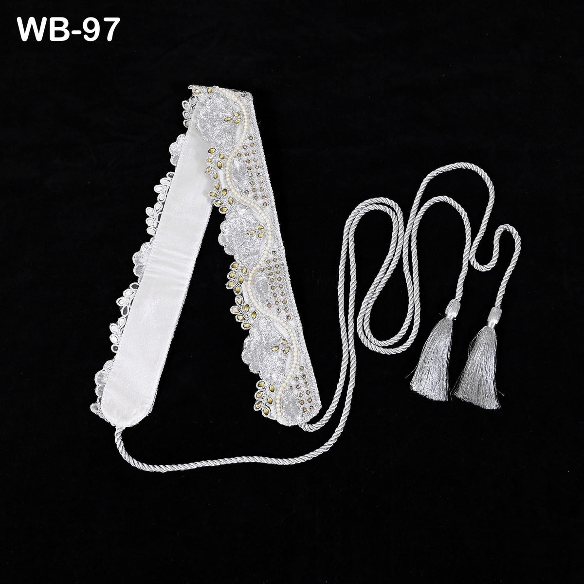 a white, decorative headband with tassels and a lace-like trim, placed on a black background.