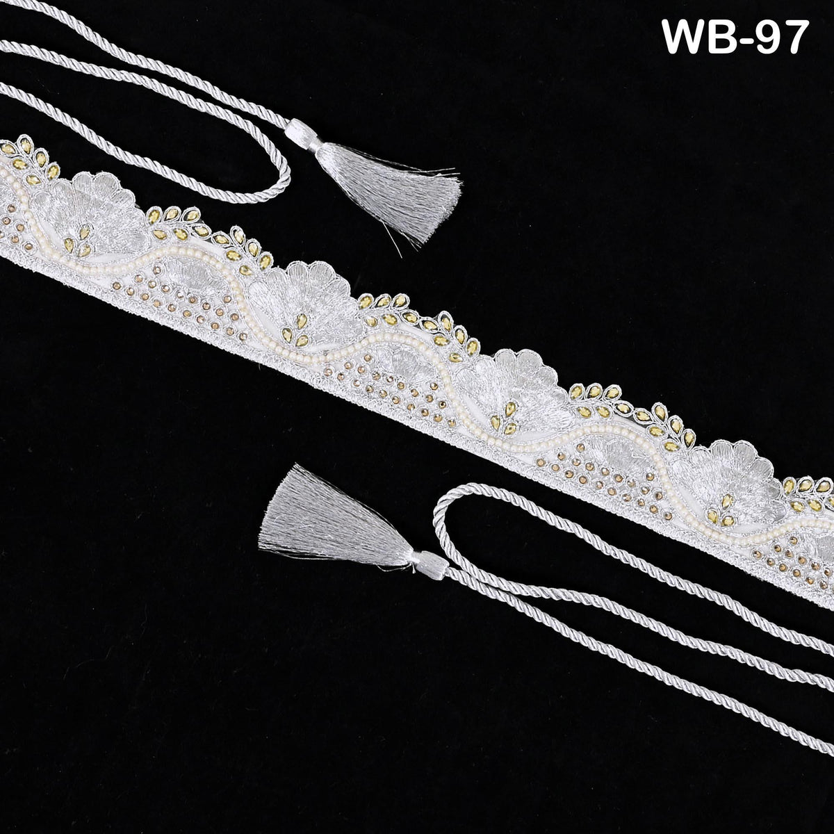 a decorative white lace trim with tassels, displayed against a black background.