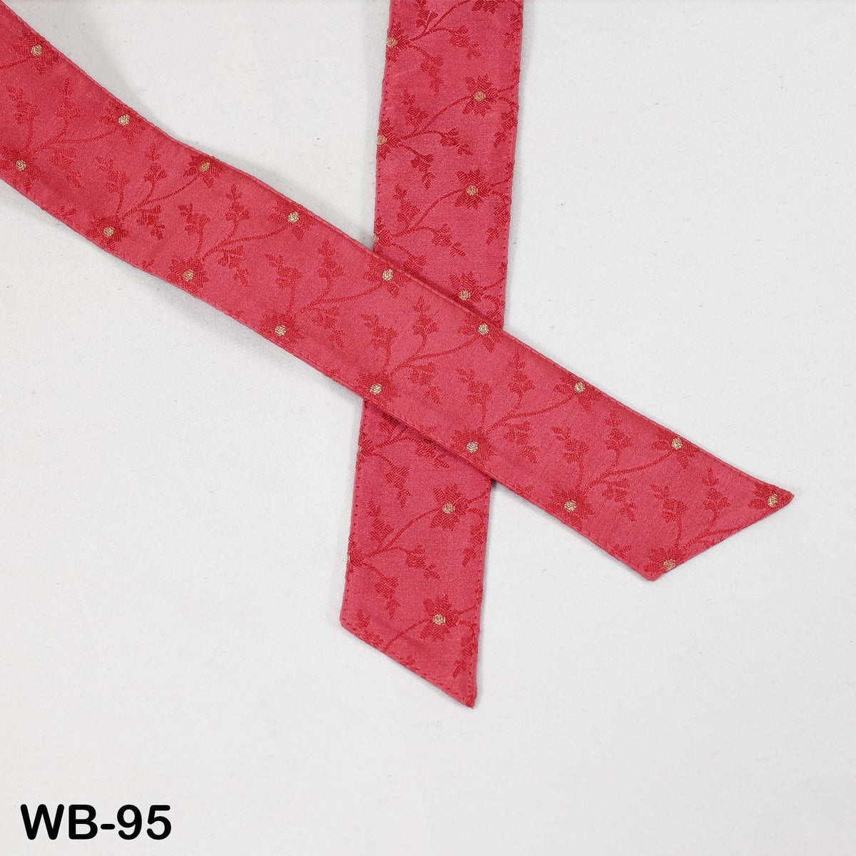 a red fabric with a floral pattern, folded and placed on a white background.
