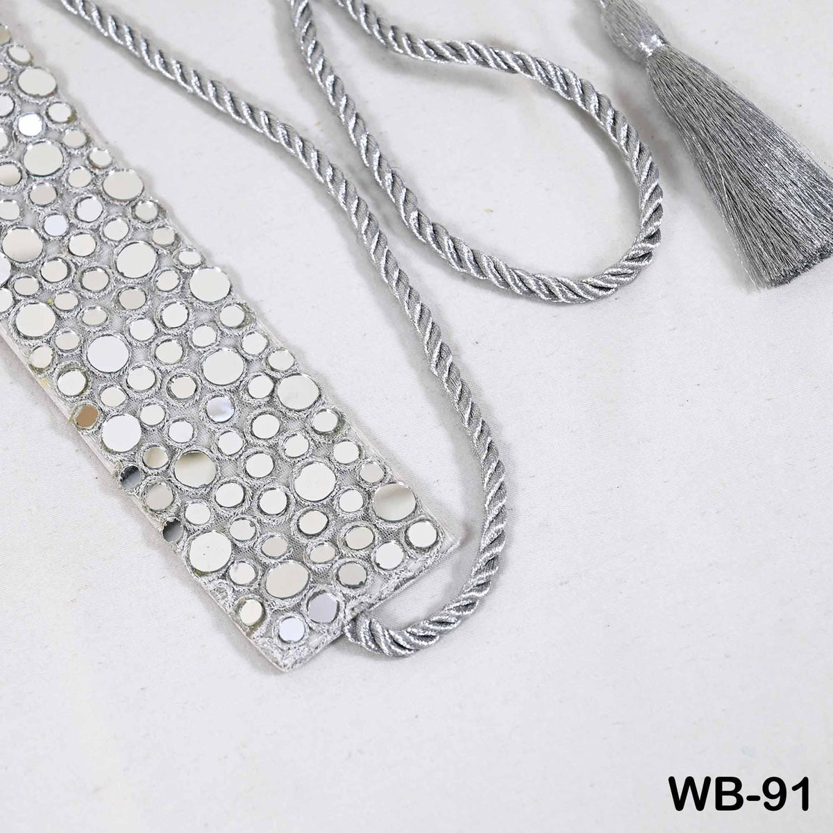 a silver-colored decorative piece with a tassel and a silver-colored rope.