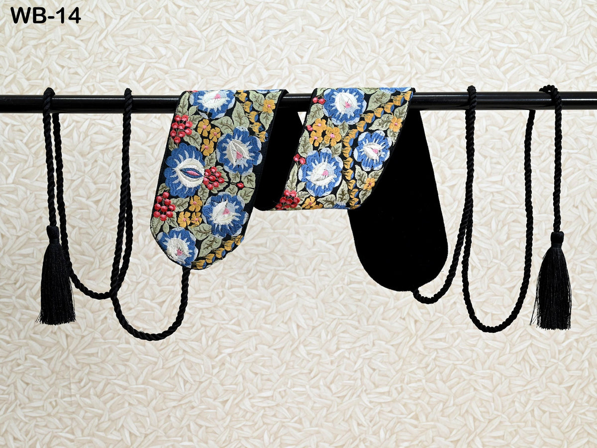 two colorful pajama pants hanging on a rack, with black tassels hanging from the ends of the pants.