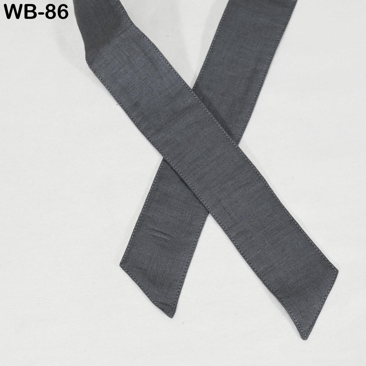 A gray fabric ribbon is crossed over itself, creating a decorative pattern.