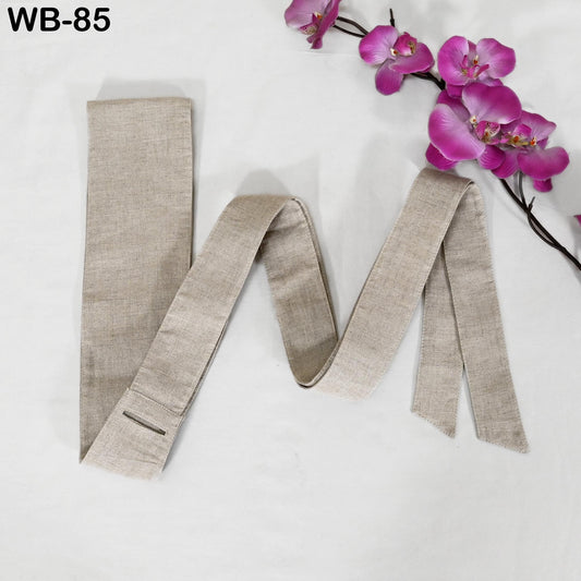 a beige tie with a floral arrangement of pink orchids placed next to it on a white background.