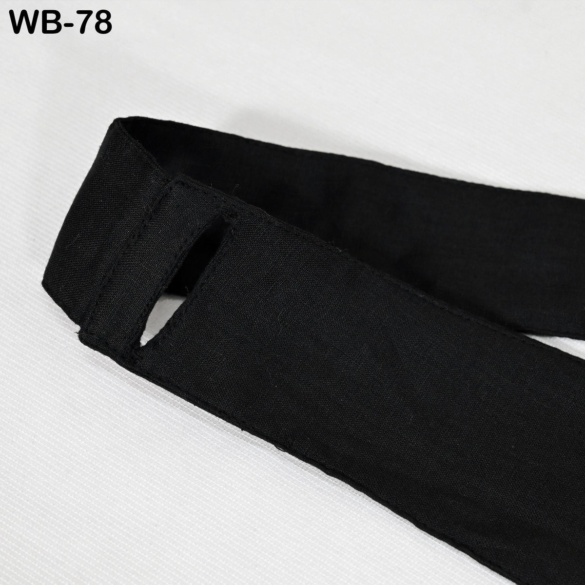A close-up view of a black fabric, possibly a piece of clothing or a textile, with a visible cut or tear.