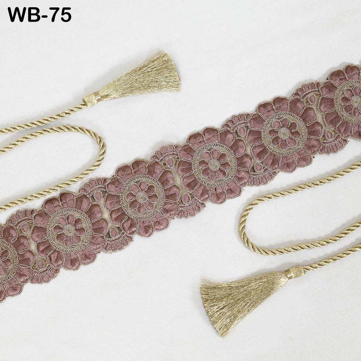 a decorative floral lace trim with gold tassels, arranged on a white background.