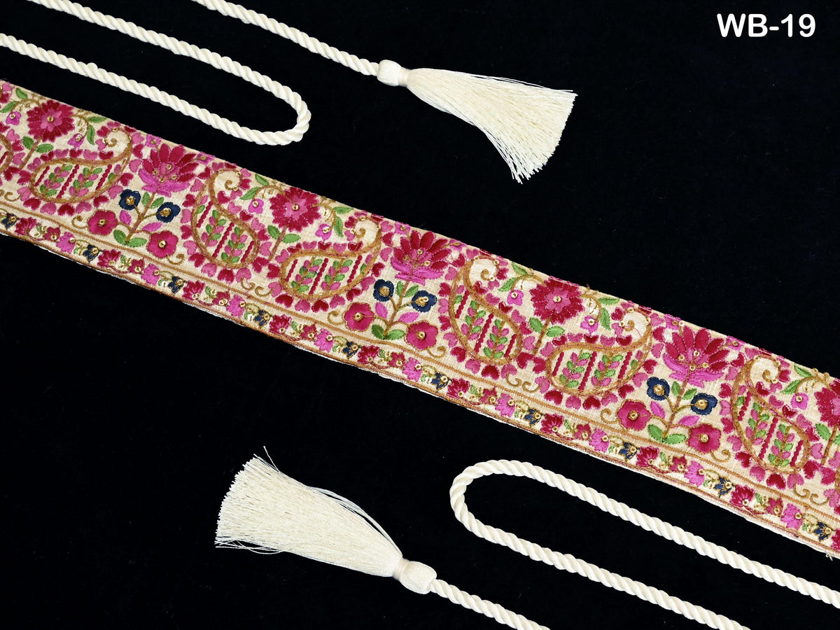 a decorative border with a floral pattern and white tassels, placed against a black background.