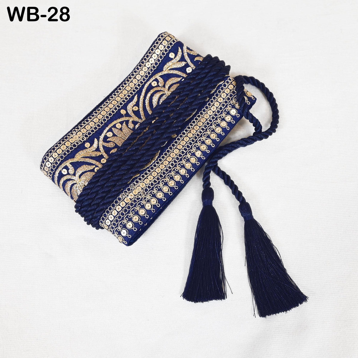 A decorative blue and gold fabric with intricate patterns and tassels, placed on a white background.