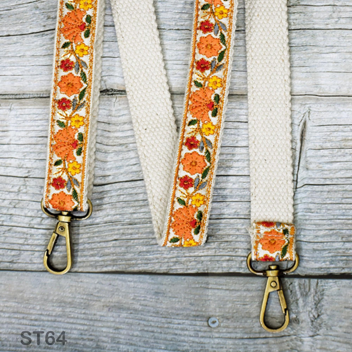a pair of white straps with a floral pattern, attached to a wooden surface.