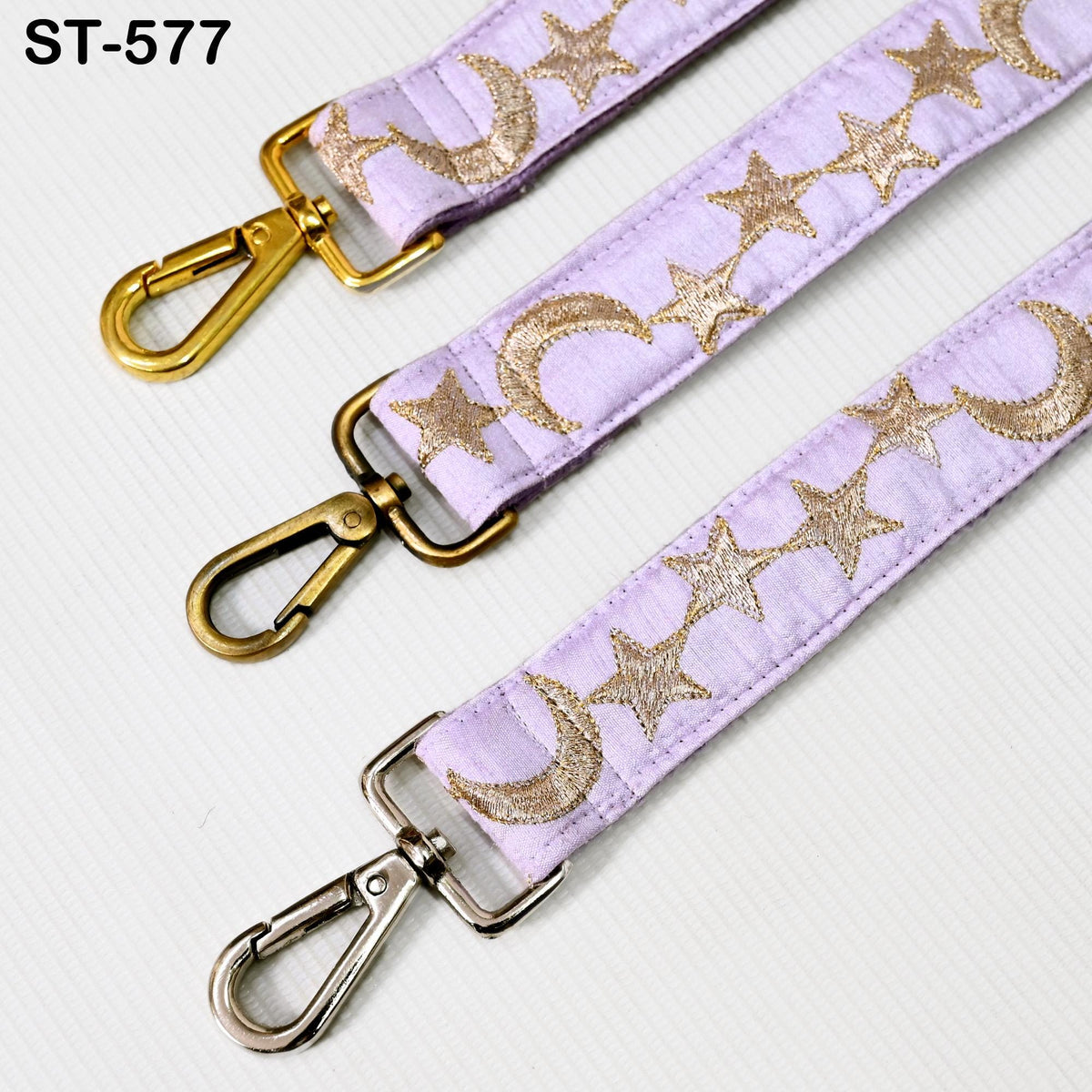 three straps with metallic buckles and star patterns, arranged in a row.
