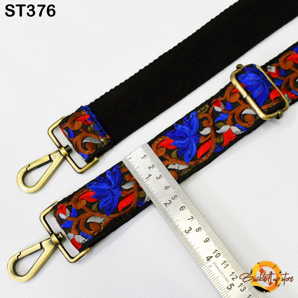a colorful strap with a black buckle, a ruler, and a gold-colored metal hook.