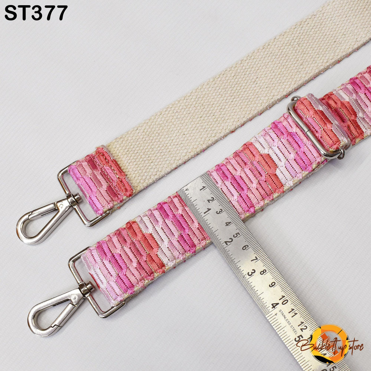 a strap with a metal clasp and a ruler placed next to it, indicating the strap's size.