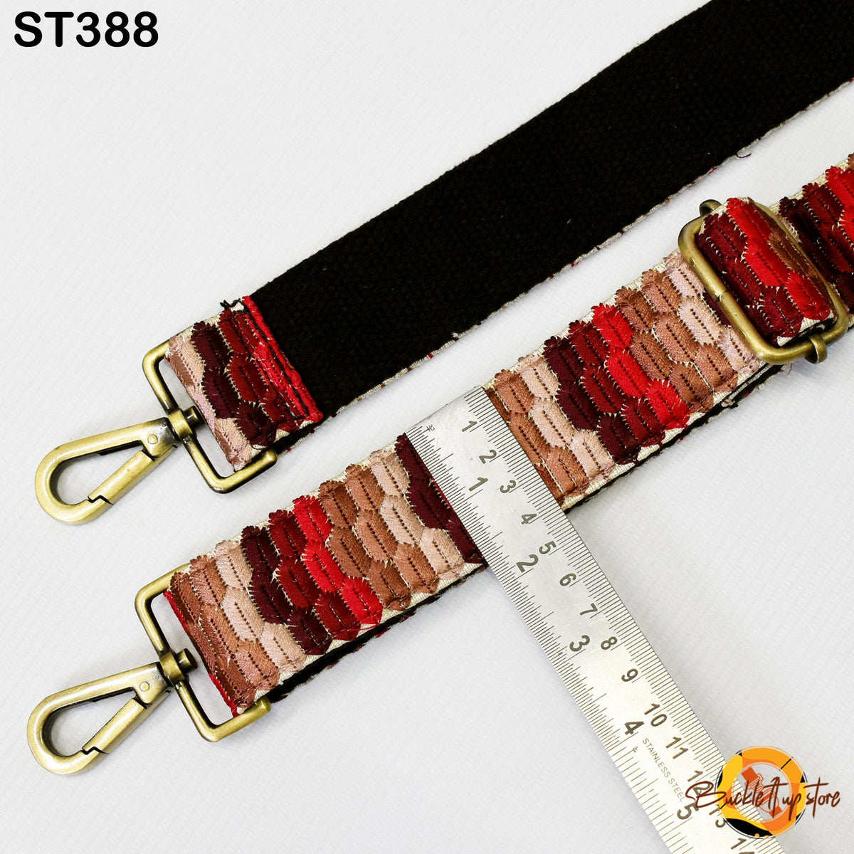 a strap with a black and red patterned design, and a ruler is placed next to it, indicating the strap's length.