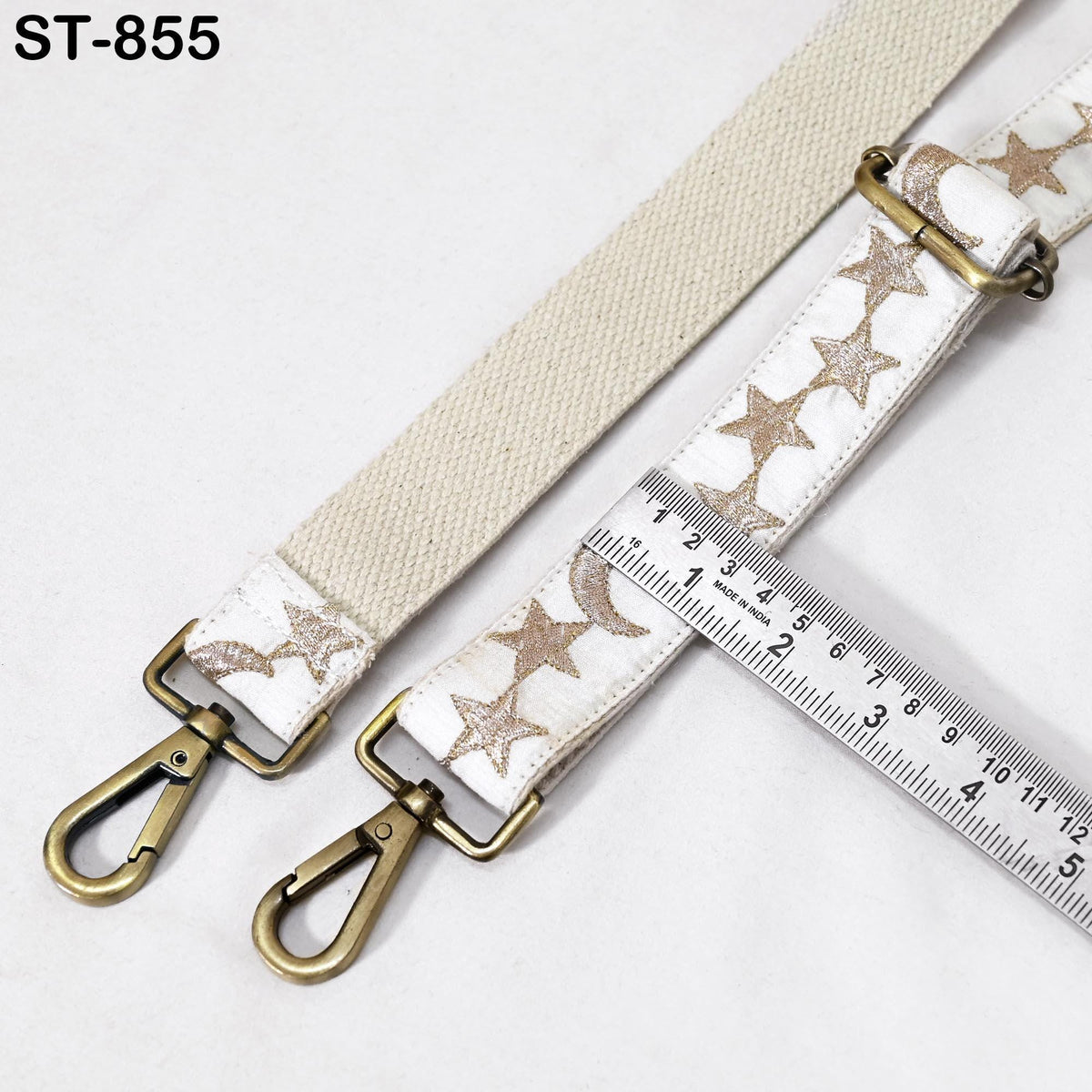 a beige strap with a metallic buckle and a ruler placed on a white surface.