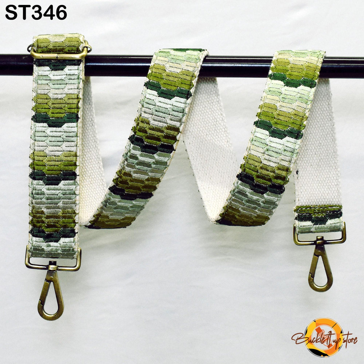 a colorful, patterned strap with a metal hook attached to it, hanging on a black bar.
