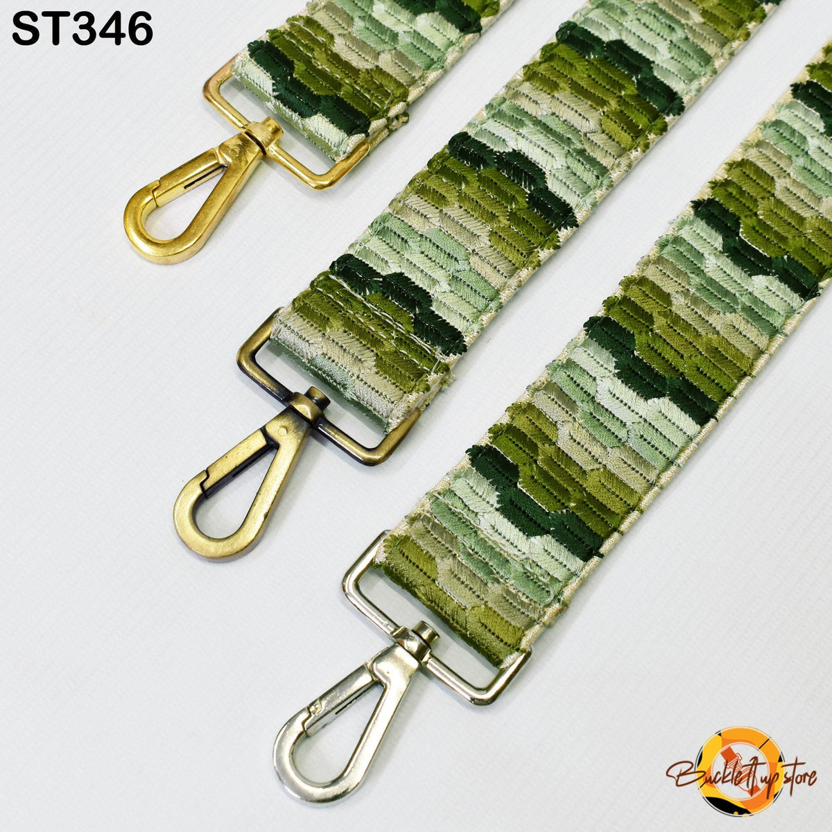 three different straps with a camouflage pattern, each with a metal hook or clasp. The straps appear to be made of a fabric with a green and brown color scheme.