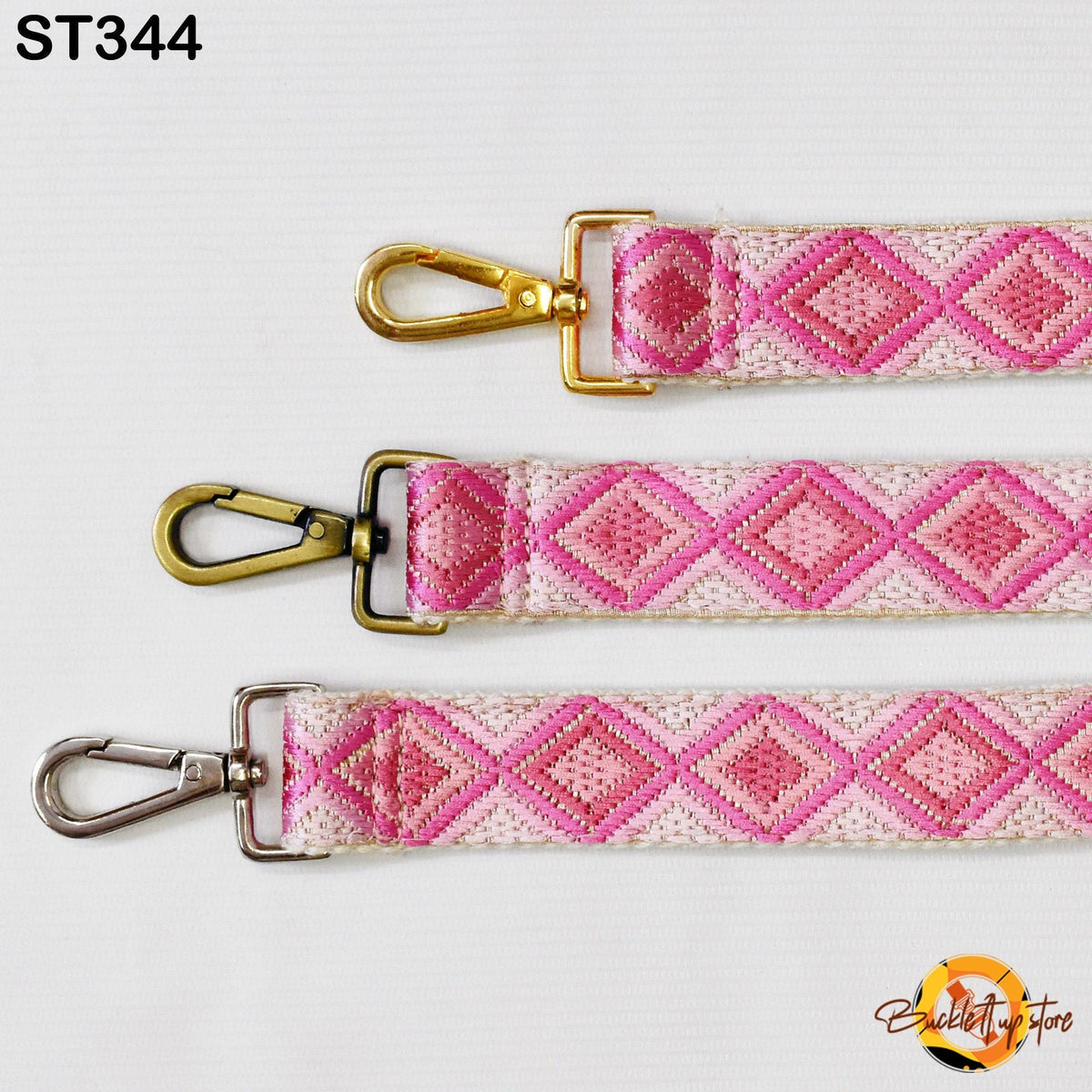 three straps with a pink and white diamond pattern, each with a metal clasp and hook. The straps appear to be made of fabric and are displayed against a white background.