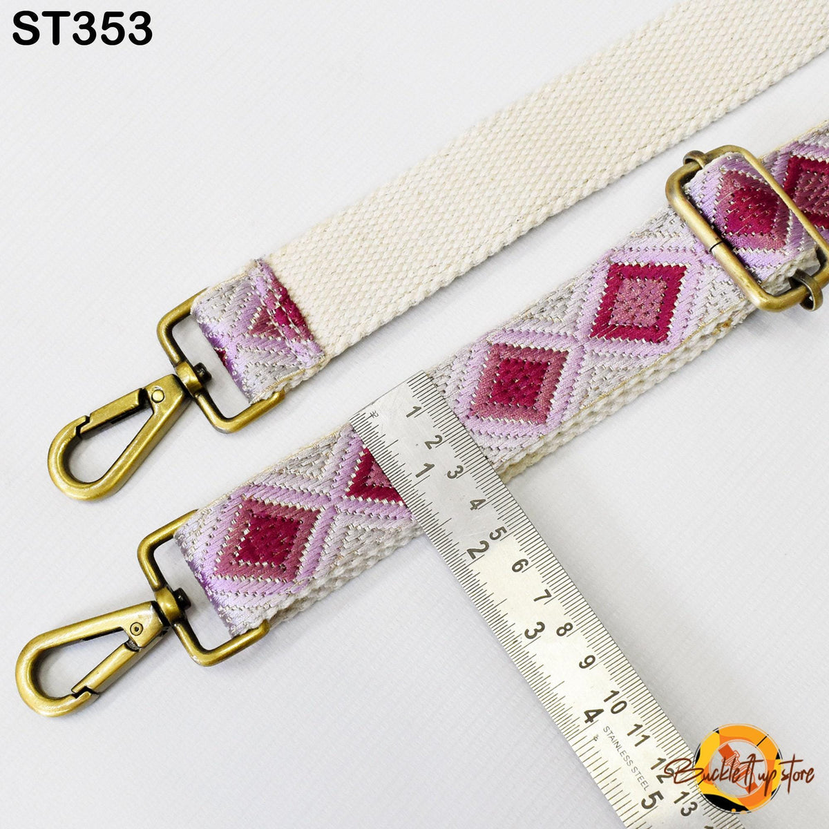 a strap with a metal clasp and a ruler placed on top of it, indicating the strap's size.