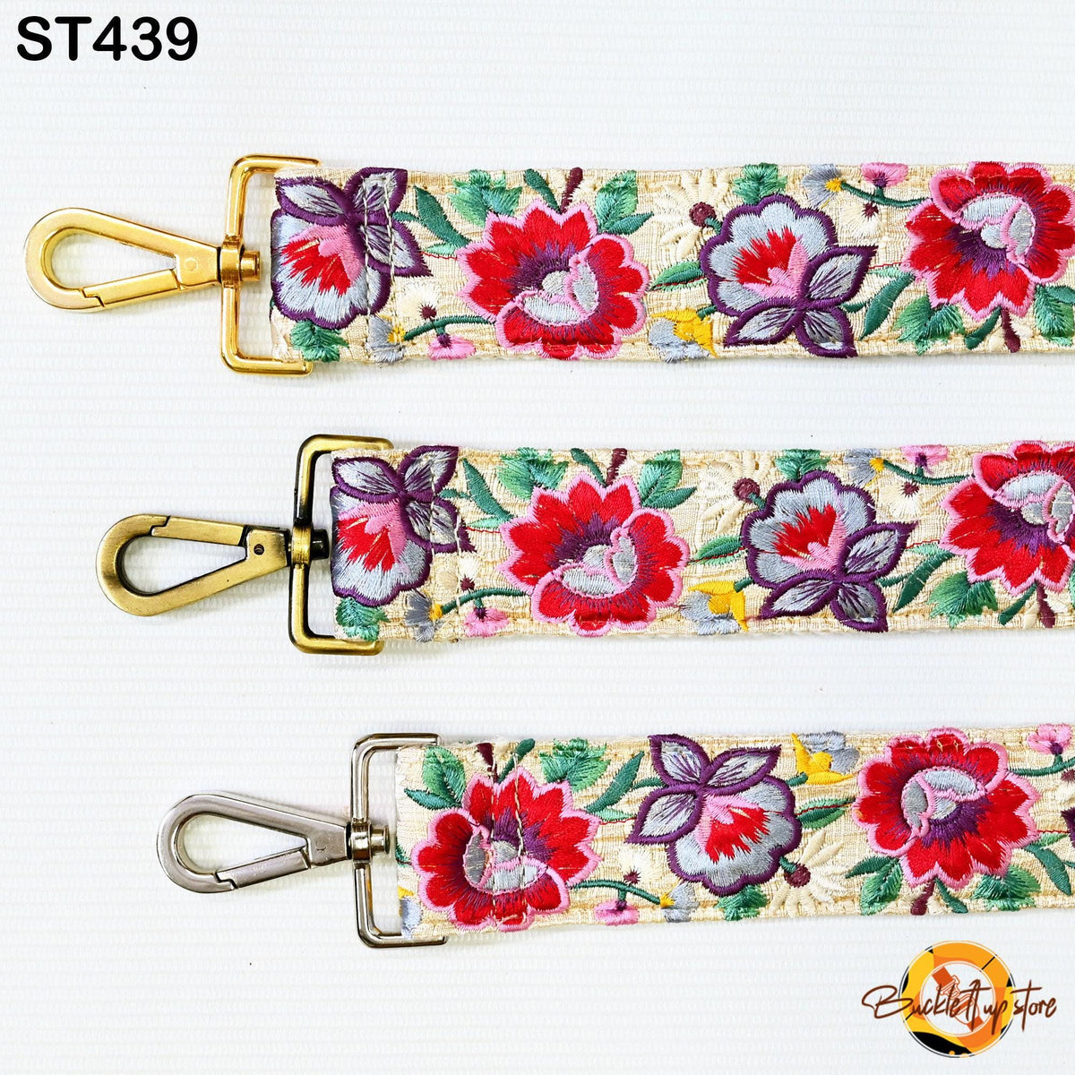 three colorful straps with floral patterns, each featuring a gold metal clasp and a silver metal loop.