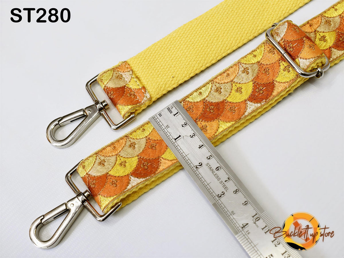 a yellow strap with a patterned design, and a ruler is placed next to it, indicating the strap's length.