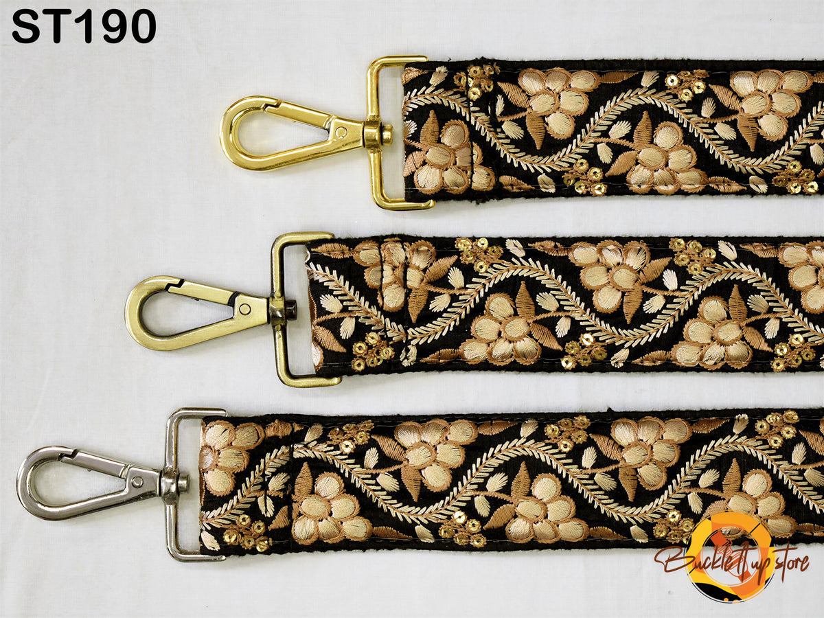 three straps with gold and black floral embroidery, each with a metal clasp and hook.