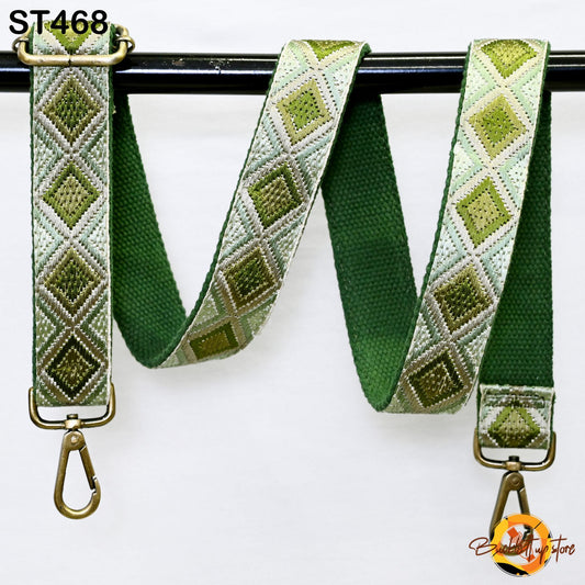 A green and white patterned strap with a metal hook attached, hanging on a black bar.