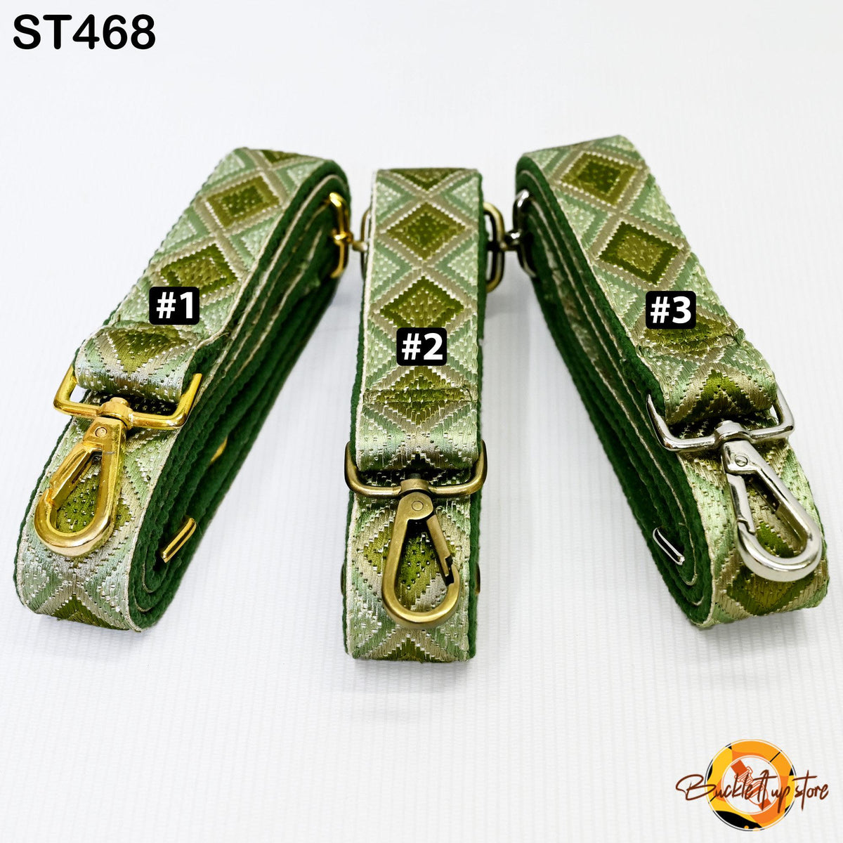 three green and gold patterned straps, each with a metal clasp and hook, arranged in a row.