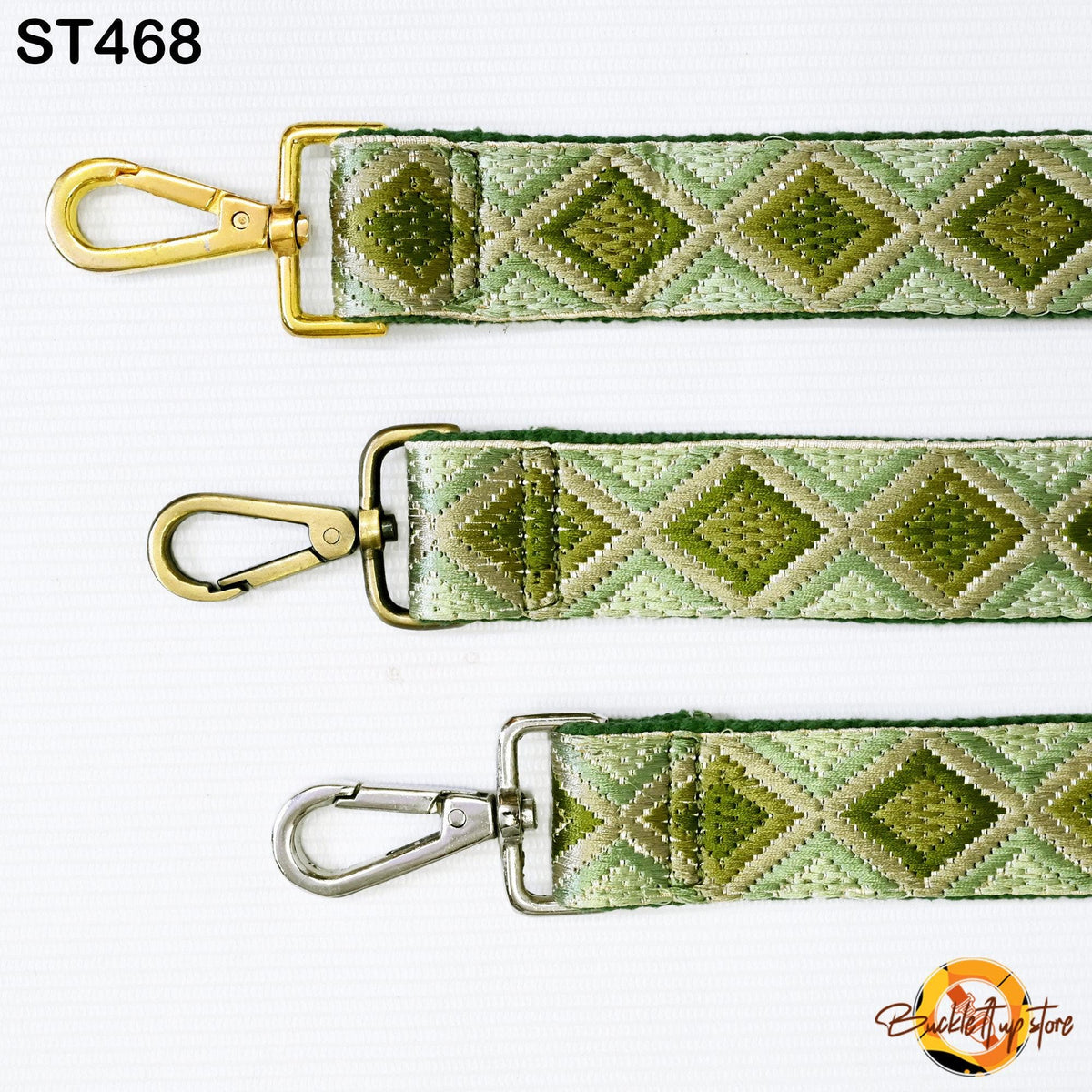 three different straps with a diamond pattern in shades of green and beige. The straps have metal hooks and buckles, and they appear to be made of a woven material.