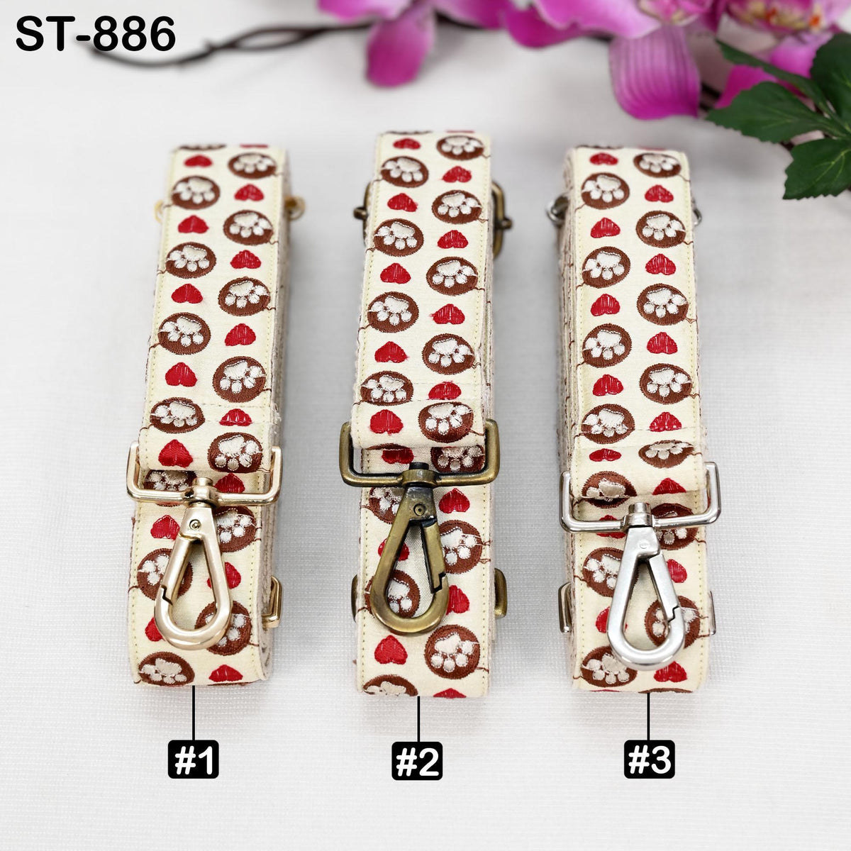 Three straps with a pattern of paw prints and hearts, each with a different color and size, arranged in a row.