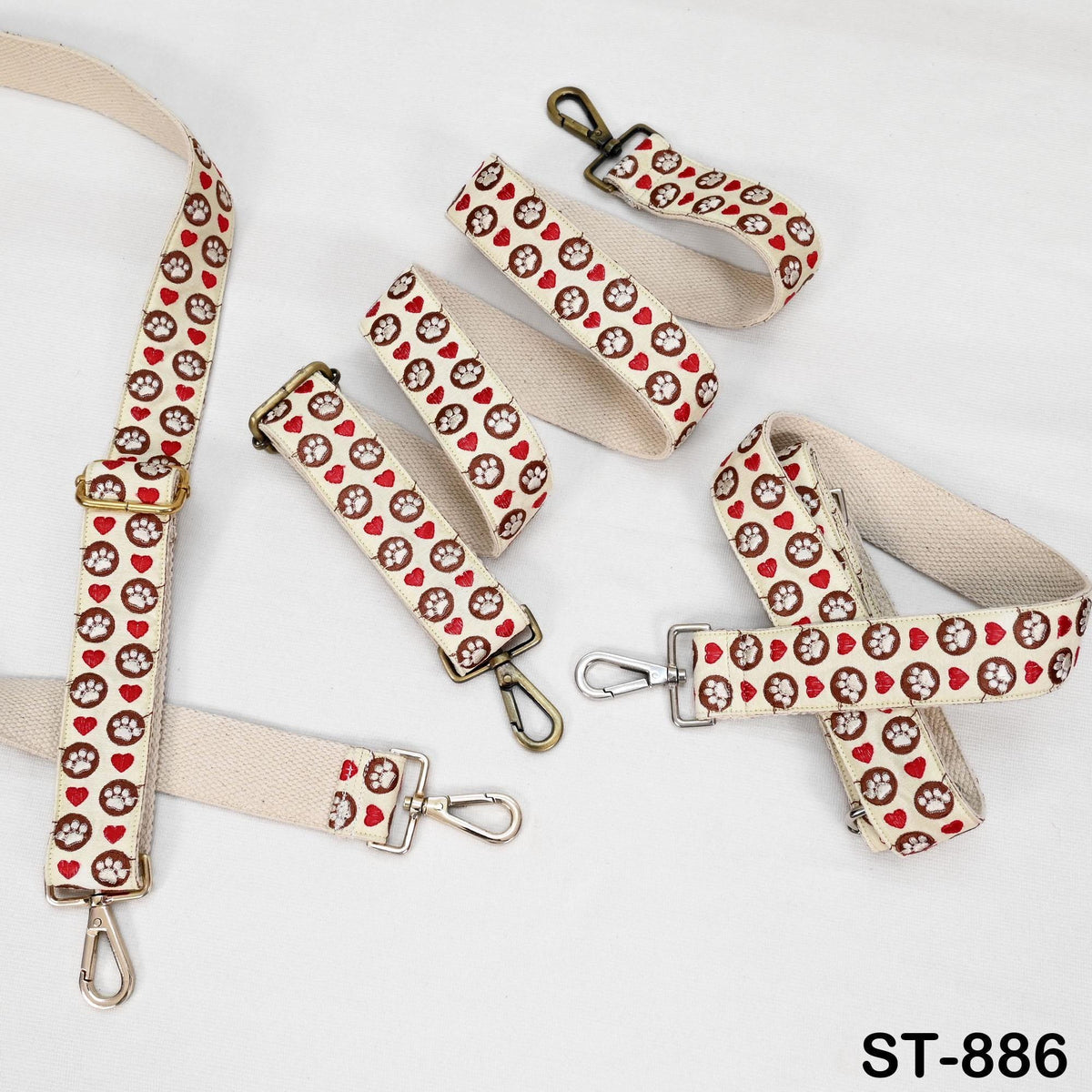 a collection of beige straps with red heart and paw print patterns, arranged on a white background.