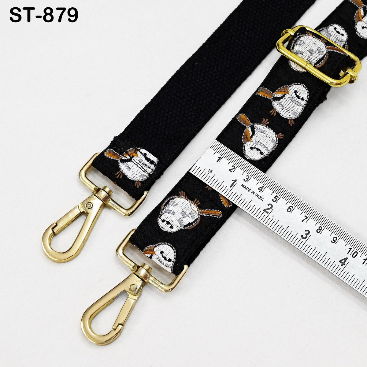 a black strap with a gold metal buckle and a ruler placed on top of it.