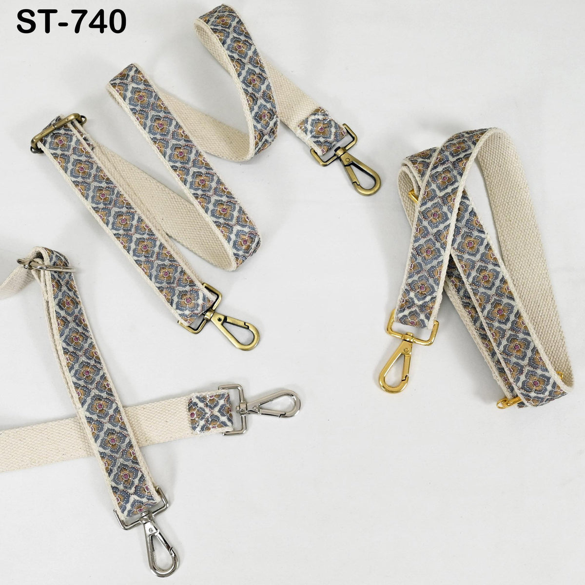 a collection of beige and gold patterned straps with metal hooks, arranged on a white background.