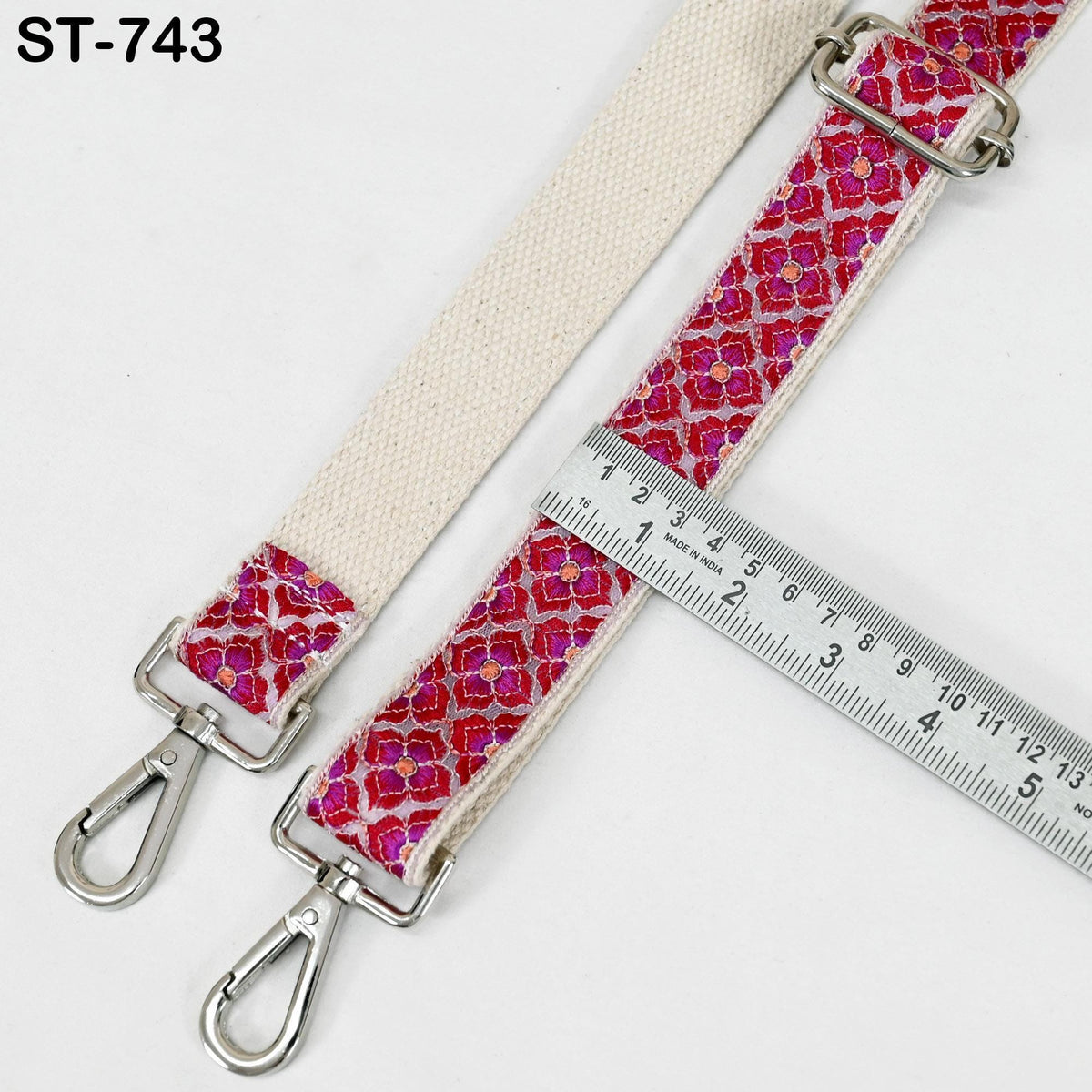 a strap with a floral pattern, and a ruler is placed next to it, indicating the strap's size.