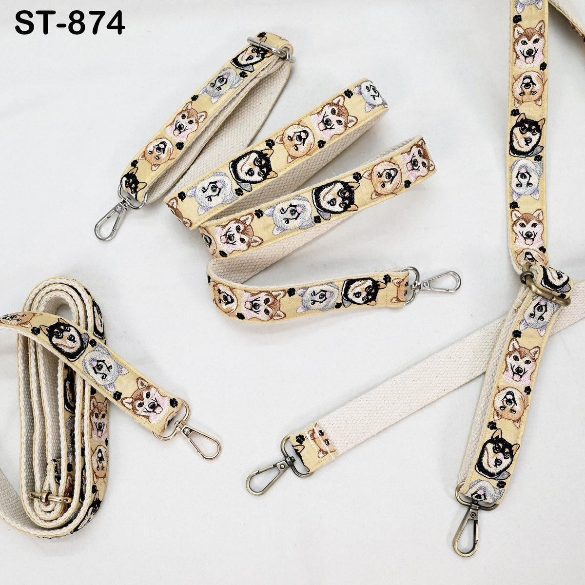 several beige straps with a repeating pattern of dog faces on them. The straps appear to be made of a soft, woven material and are designed for use as a leash or strap.