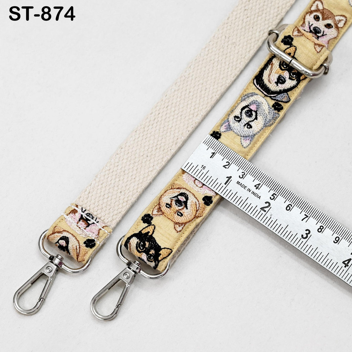 a beige strap with various dog-themed embroidered designs, including a ruler for size comparison.