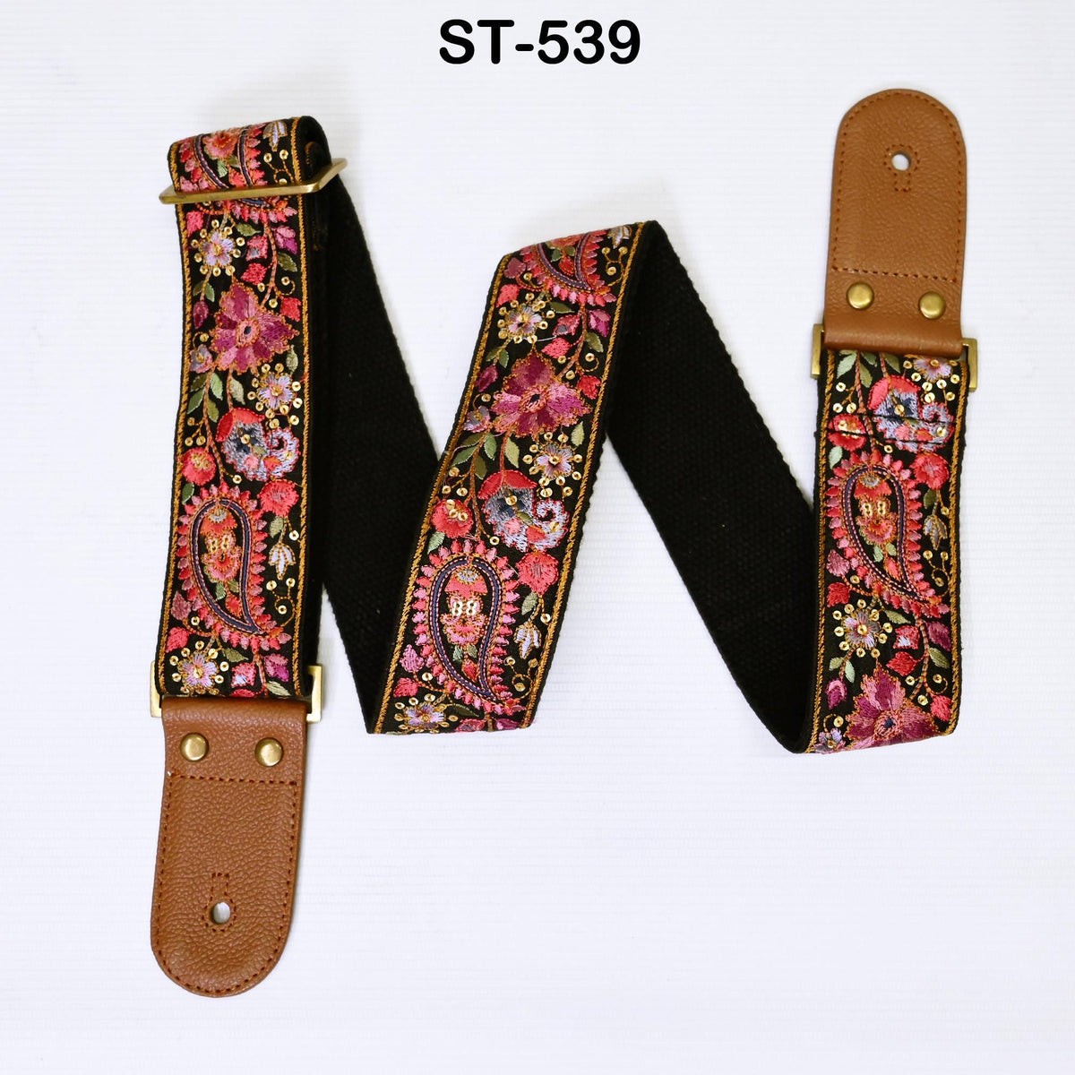 A brown guitar strap with a floral pattern and a black background.
