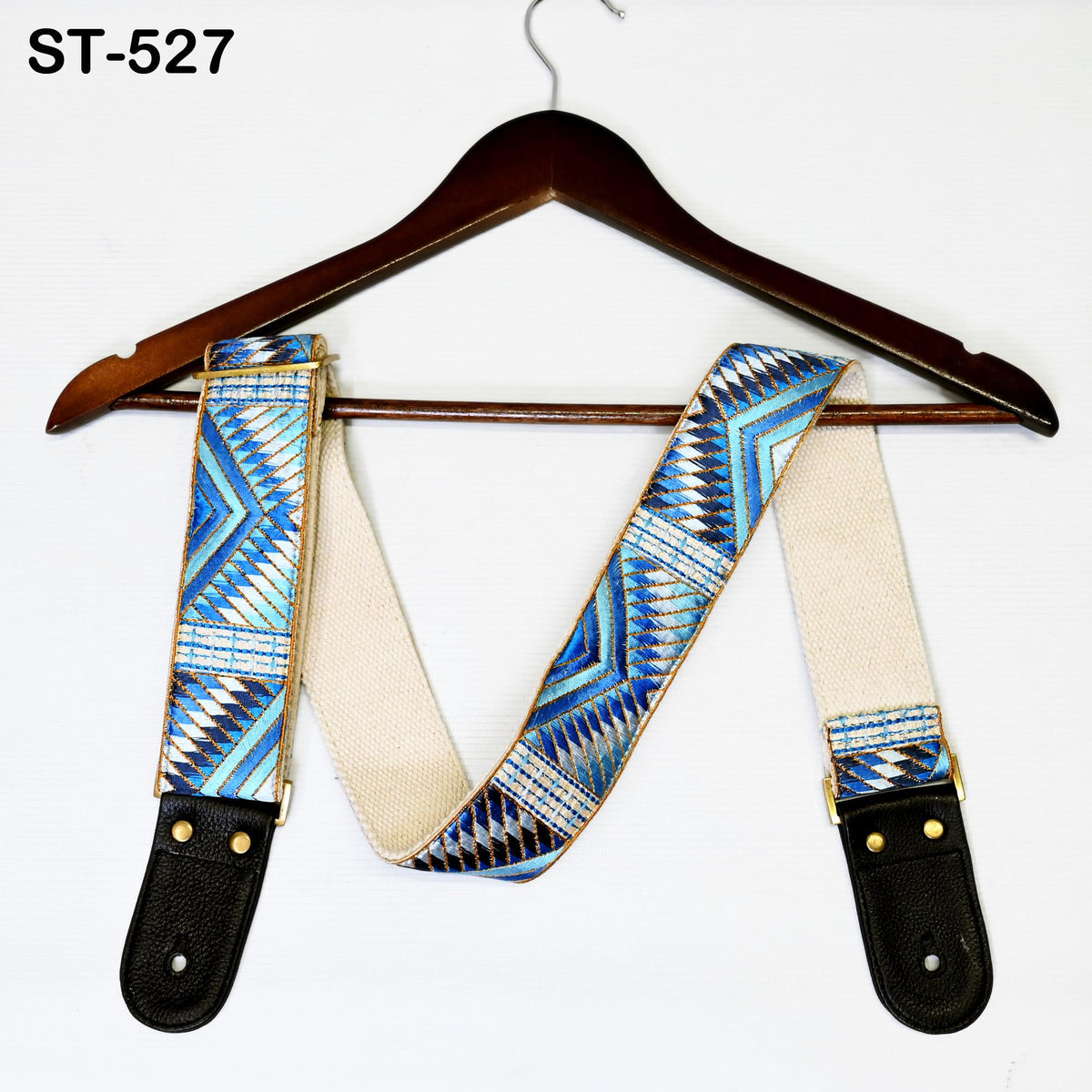 A wooden hanger with a patterned blue and white strap is displayed against a white background.