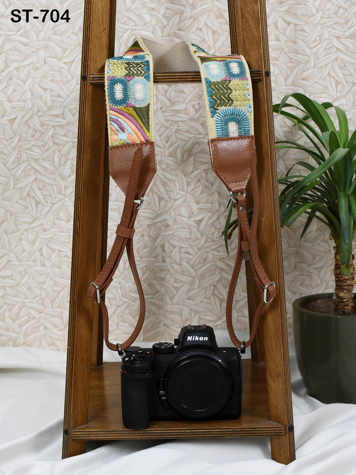 a wooden stand with a black camera on it, and a potted plant in the background.