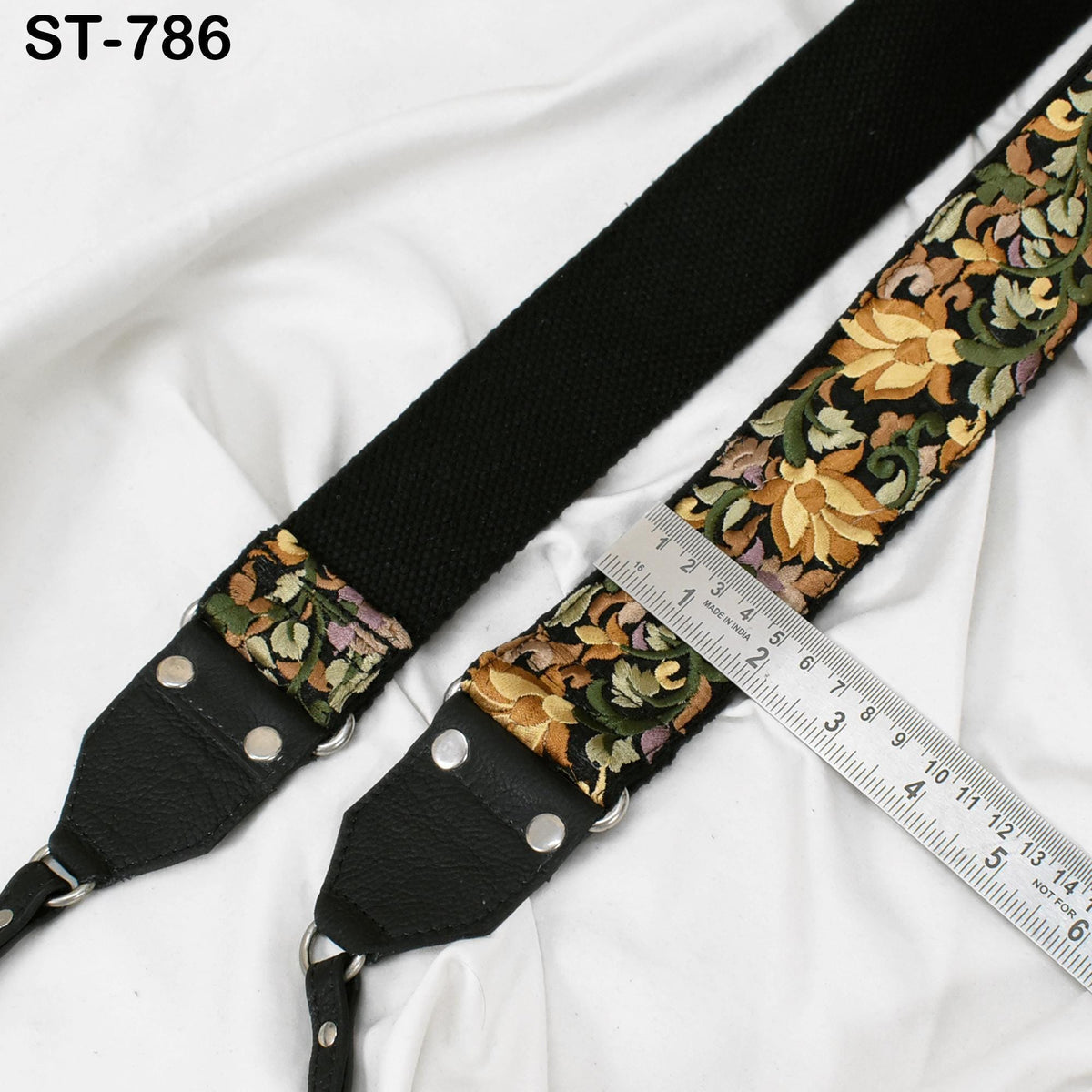 A black strap with a floral pattern and a ruler placed on top of it, indicating the strap's length.