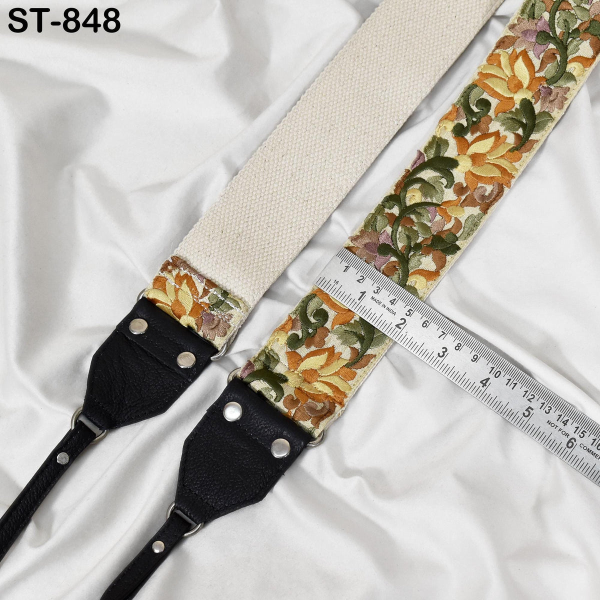 A floral patterned camera strap with a ruler placed next to it, indicating the strap's length.