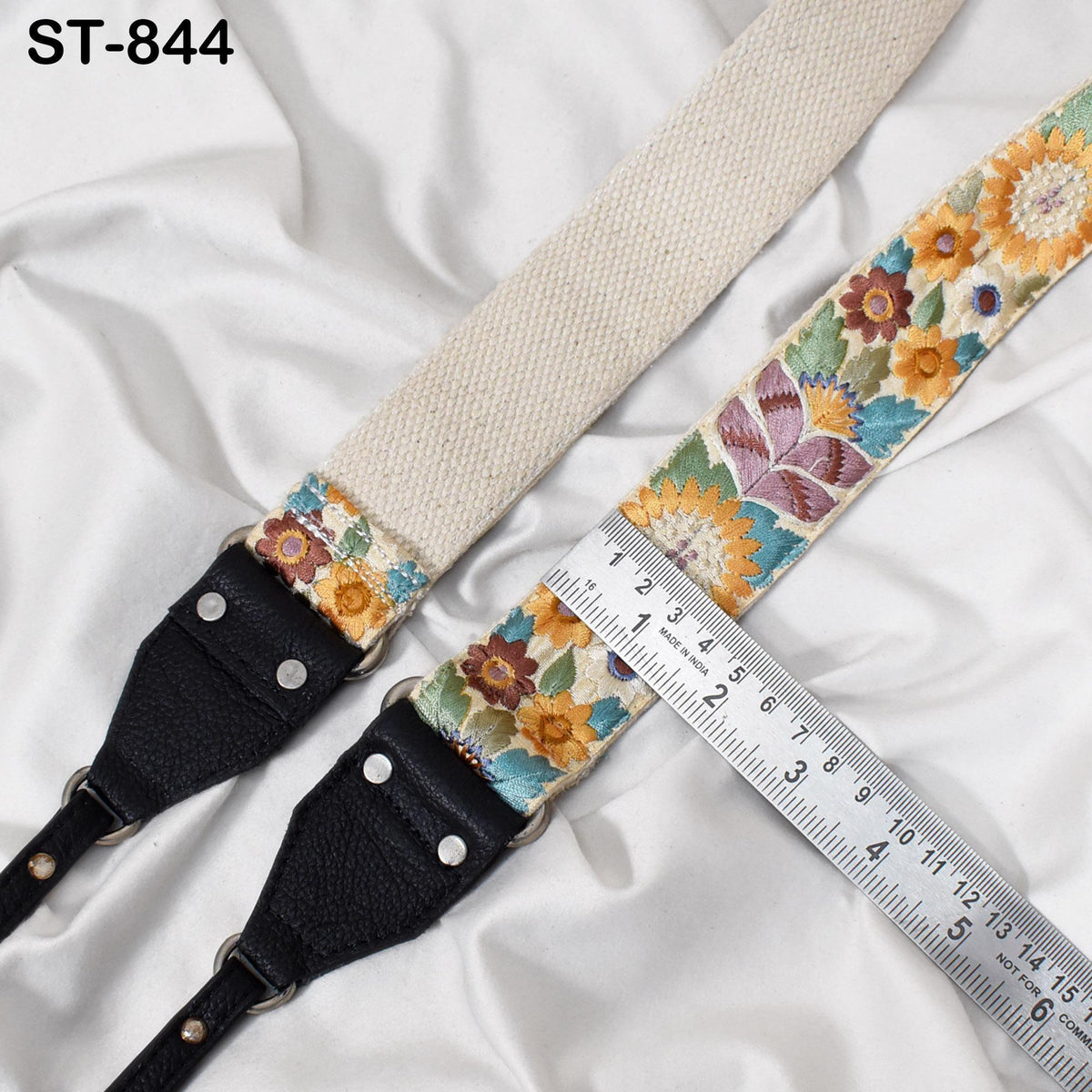 A floral-patterned strap with a ruler placed next to it, indicating the strap's length.